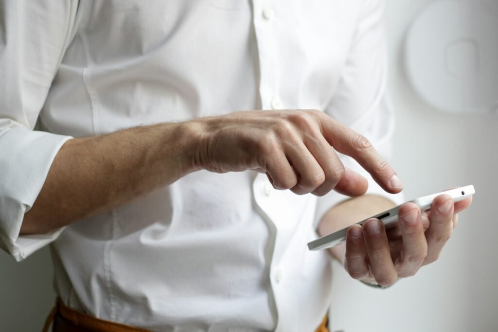 Person holding white Android smartphone in white shirt